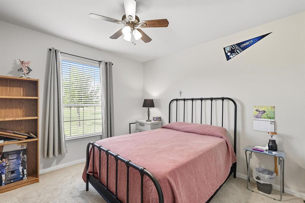 142 High Ridge Court Decatur, TX 76234 - Photo 19 of 40 a bedroom with a bed and a chandelier