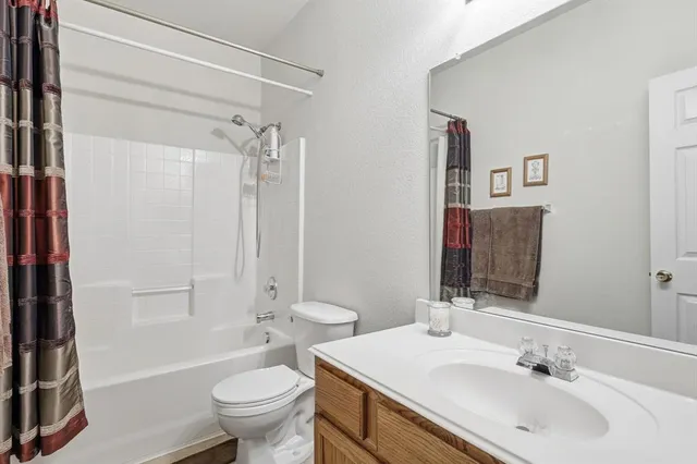 a bedroom with a bed and a large mirror on the dresser