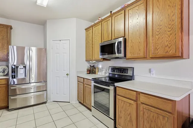 a kitchen with granite countertop a refrigerator stove and microwave