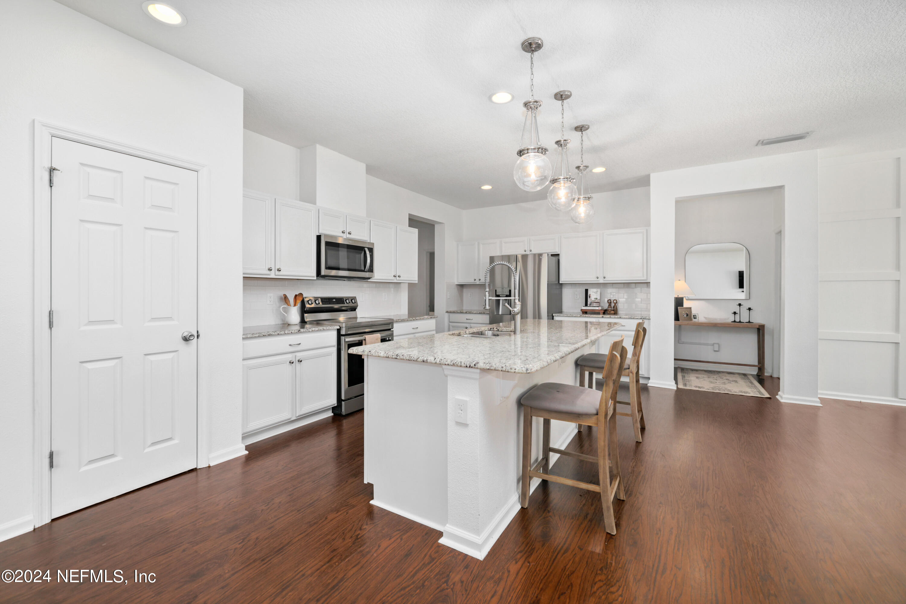192 Peter Island Drive St. Augustine, FL 32092 - Photo 2 of 43 a kitchen with kitchen island granite countertop a sink cabinets and wooden floor