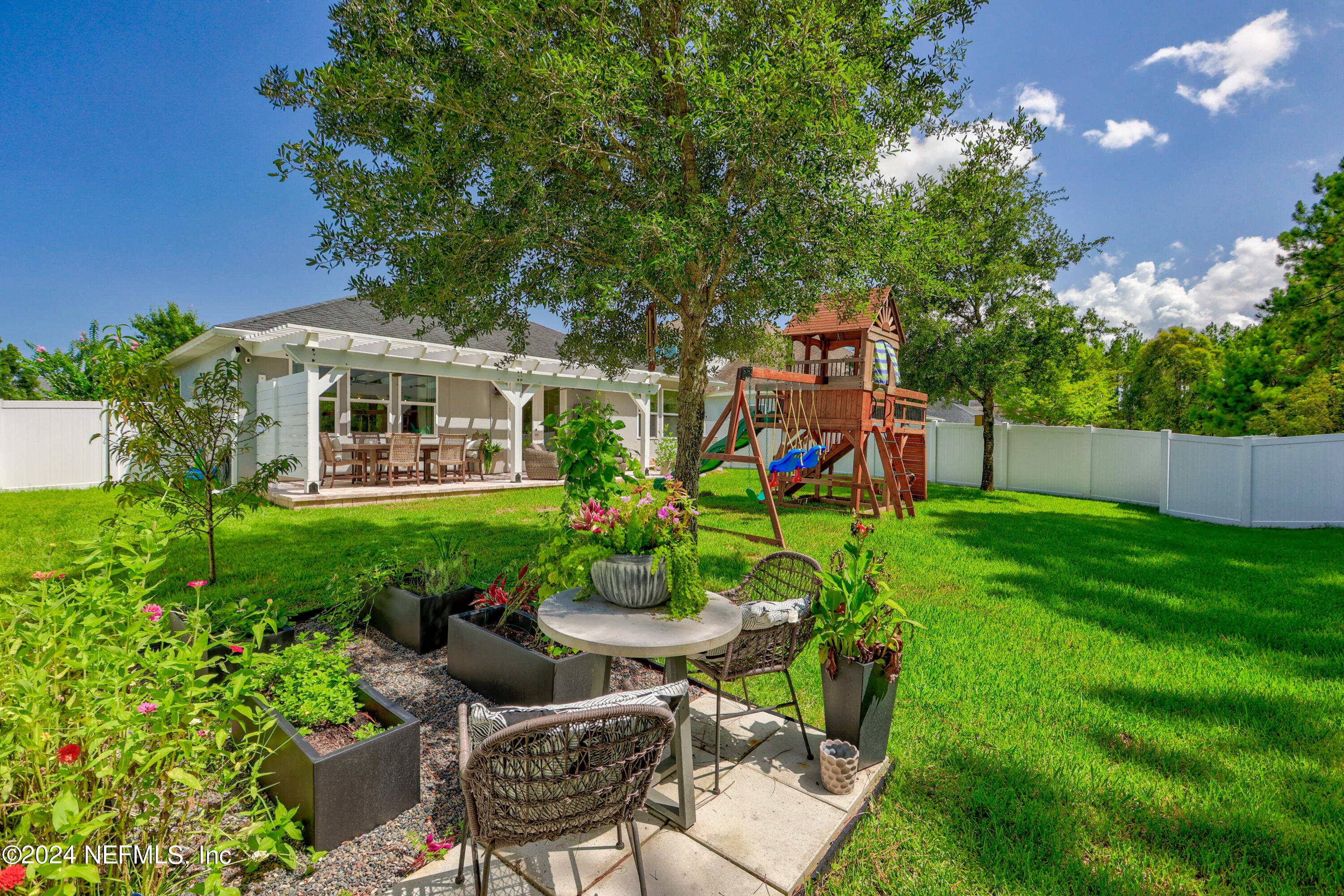 192 Peter Island Drive St. Augustine, FL 32092 - Photo 33 of 43 a view of a patio with table and chairs potted plants and large tree