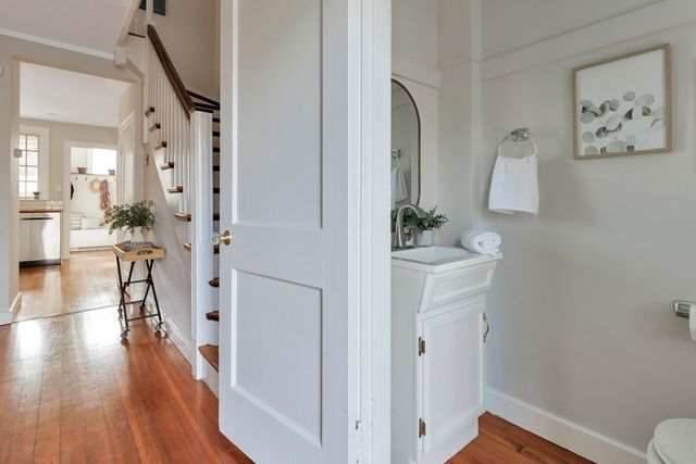 a view of a hallway with wooden floor and a living room