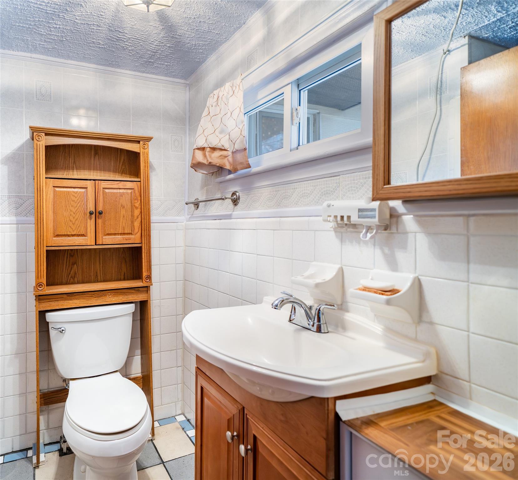 298 School Road East Asheville, NC 28803 - Photo 10 of 27 a bathroom with a sink a toilet and mirror
