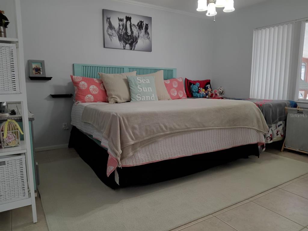 10700 Gardenwood Road Orlando, FL 32837 - Photo 13 of 23 a bed sitting in a bedroom next to a window