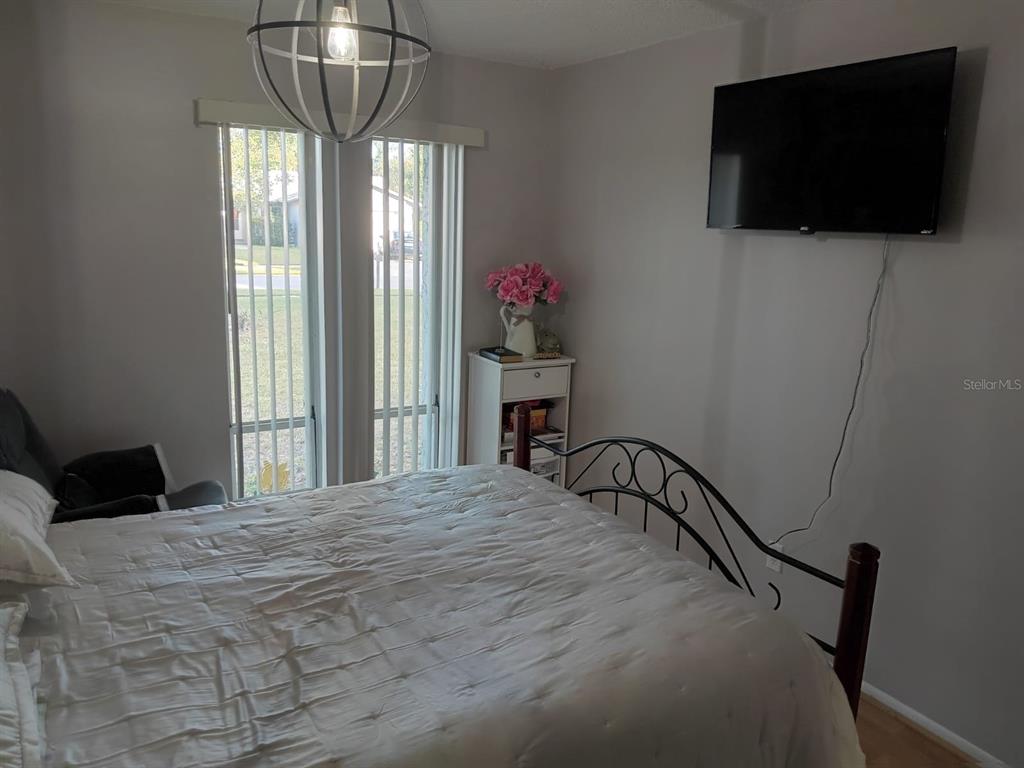 10700 Gardenwood Road Orlando, FL 32837 - Photo 15 of 23 a bedroom with a bed and a flat screen tv