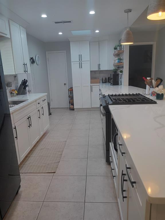 10700 Gardenwood Road Orlando, FL 32837 - Photo 5 of 23 a kitchen with a stove a sink and a refrigerator