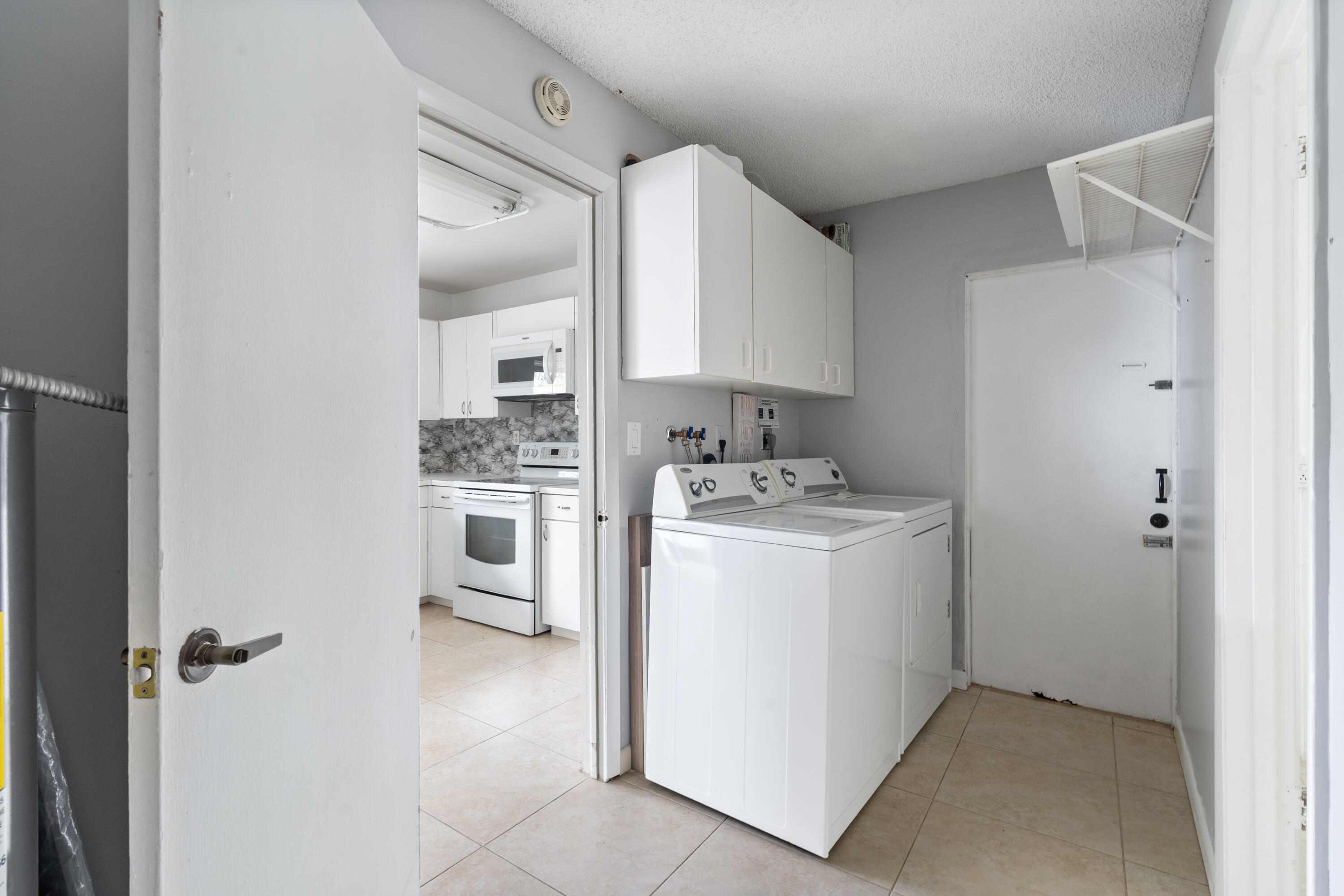 22707 Southwest 64th Way Boca Raton, FL 33428 - Photo 15 of 22 a kitchen with a refrigerator a stove top oven and cabinets