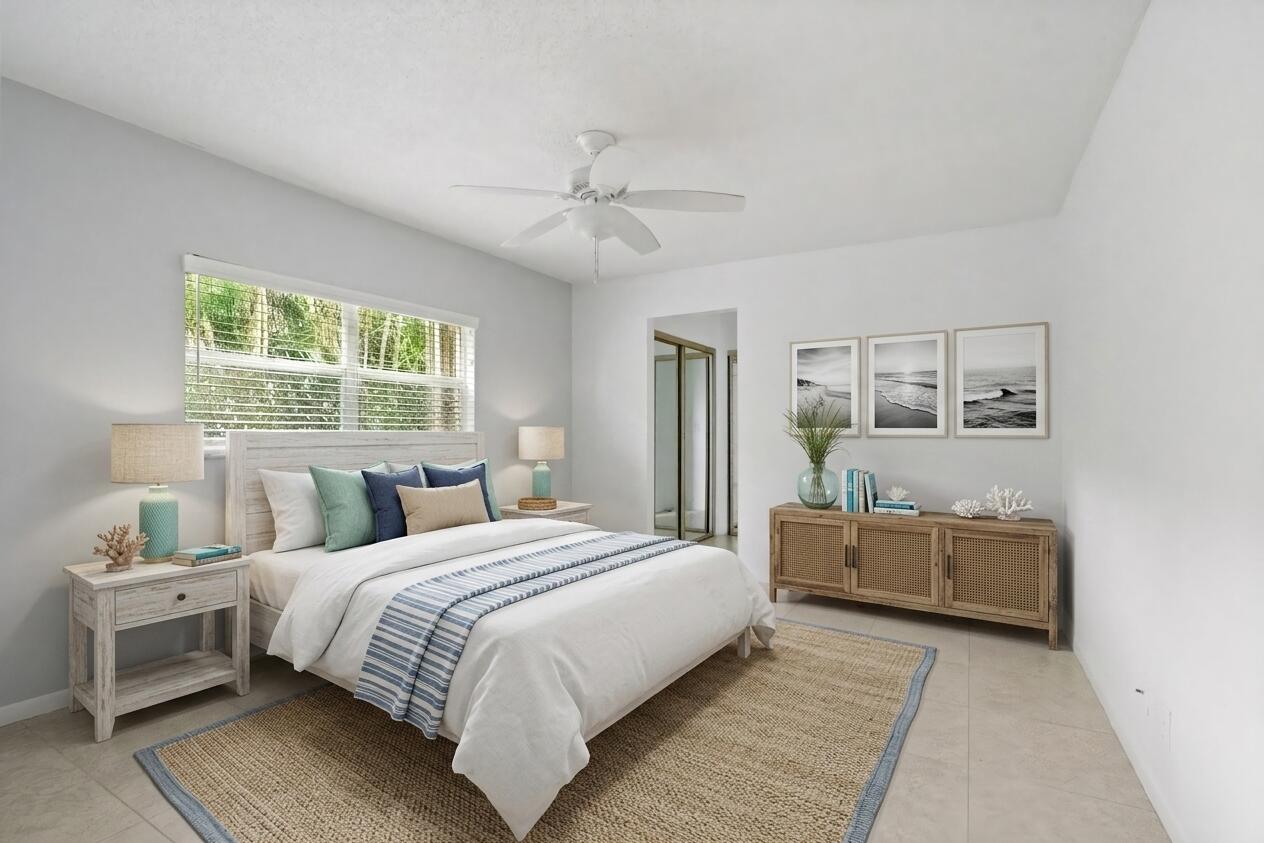 22707 Southwest 64th Way Boca Raton, FL 33428 - Photo 16 of 22 a bedroom with a large bed and a chandelier