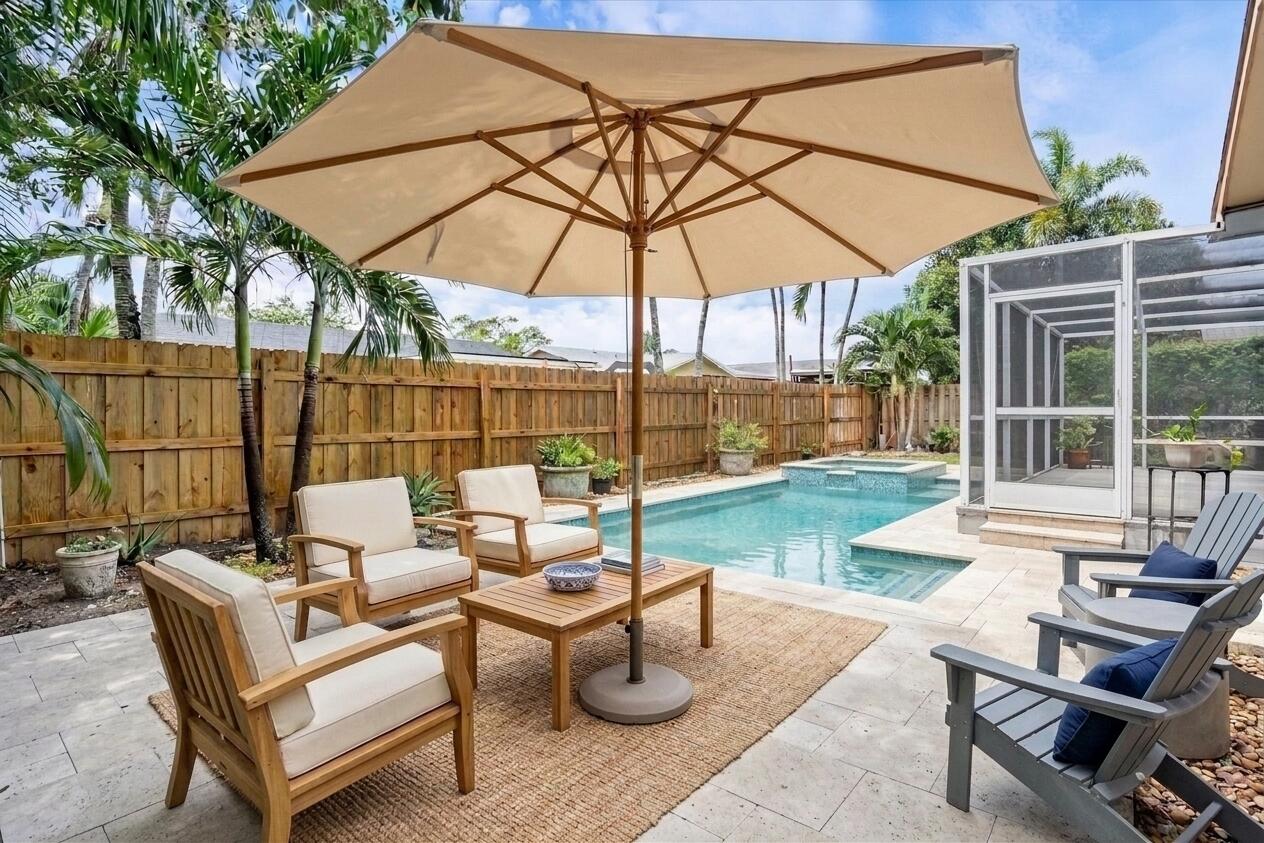 22707 Southwest 64th Way Boca Raton, FL 33428 - Photo 4 of 22 a view of a patio with a table and chairs under an umbrella