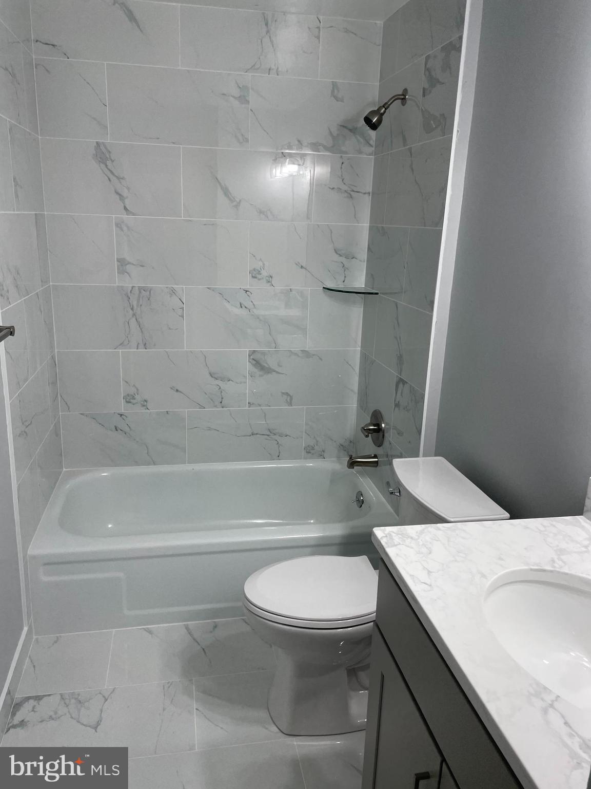 9220 Bridle Path Lane, Unit E Laurel, MD 20723 - Photo 14 of 14 a bathroom with a granite countertop bathtub shower sink vanity and toilet