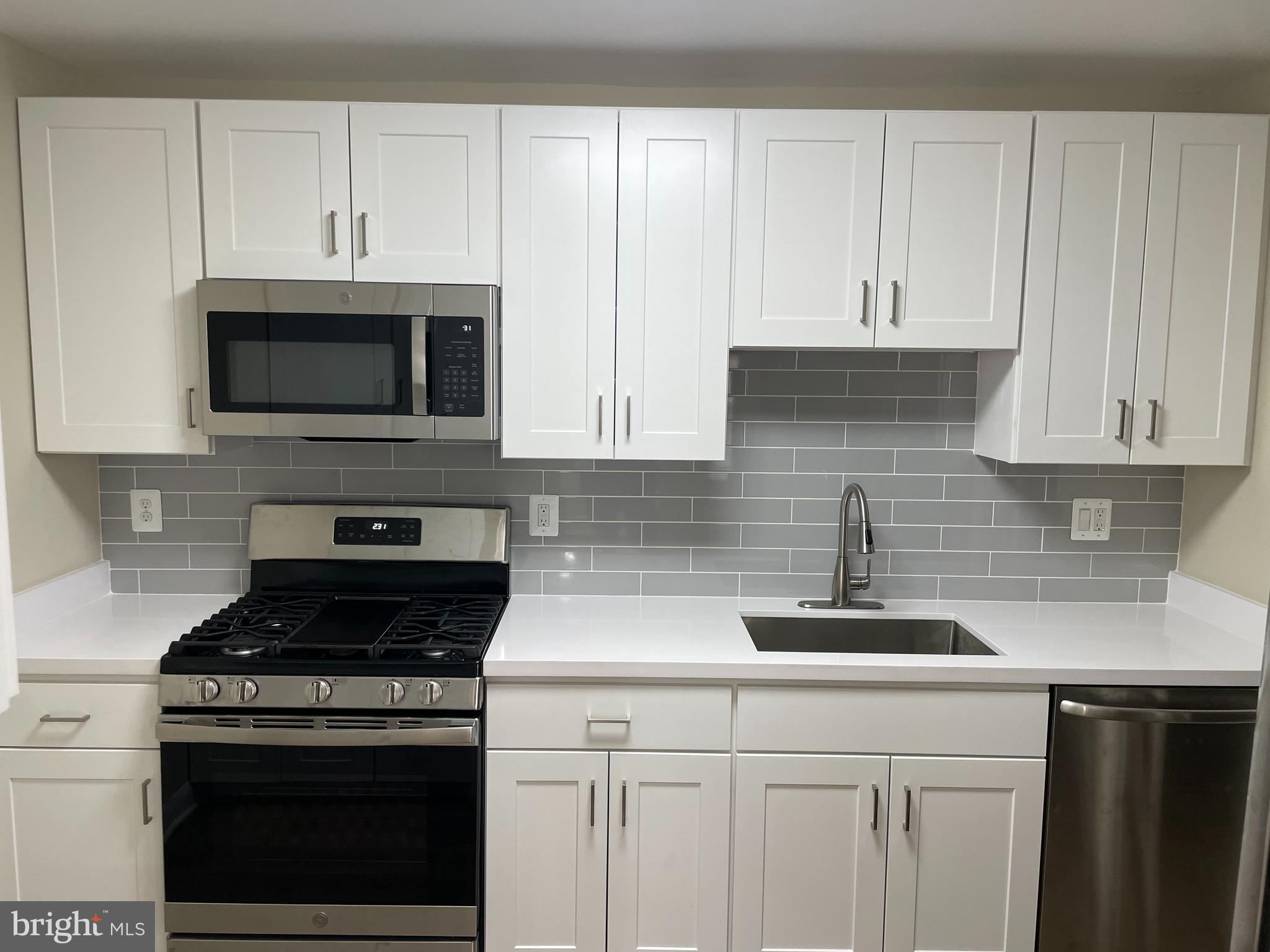 9220 Bridle Path Lane, Unit E Laurel, MD 20723 - Photo 3 of 14 a kitchen with granite countertop white cabinets and stainless steel appliances