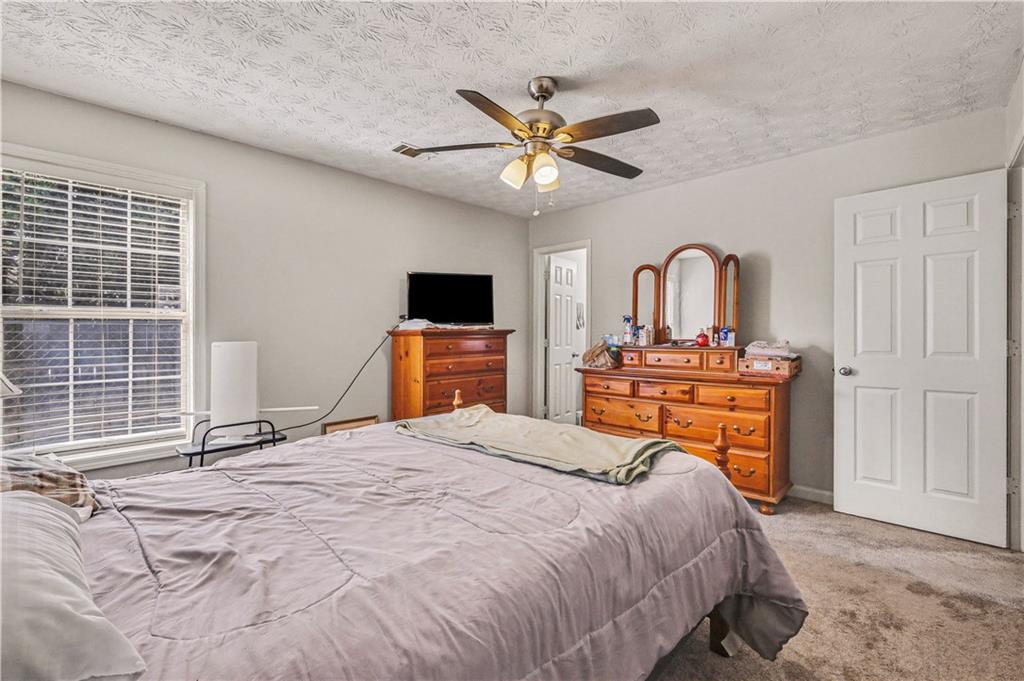 280 Courtyard Circle Winder, GA 30680 - Photo 13 of 24 a bedroom with a bed and a chandelier