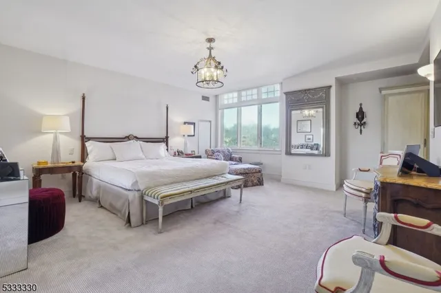 a spacious bedroom with a bed and a chandelier