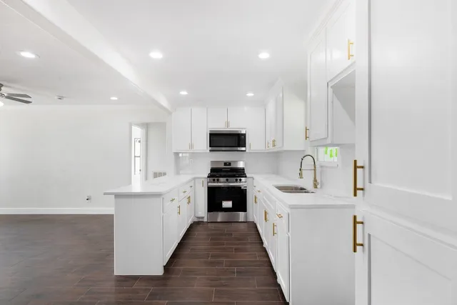 a kitchen with granite countertop a sink stove and cabinets