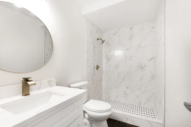 a bathroom with a sink a toilet and a mirror