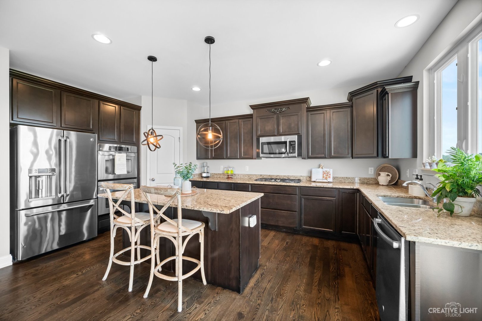 672 Ridgeview Lane Sugar Grove, IL 60554 - Photo 13 of 35 a kitchen with stainless steel appliances kitchen island granite countertop a sink a stove a refrigerator and island with wooden floor