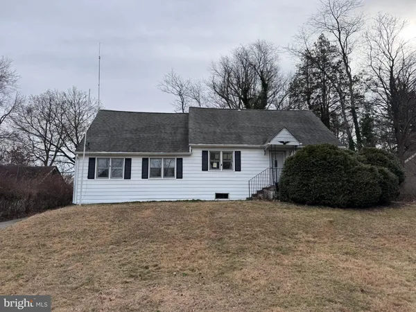 a view of house with a yard and large tree
