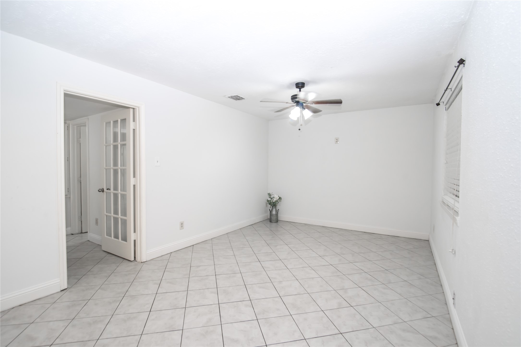 7237 Cook Road Houston, TX 77072 - Photo 8 of 21 an empty room with white walls and chandelier fan