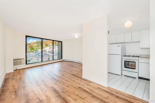 a view of a kitchen with wooden floor and electronic appliances