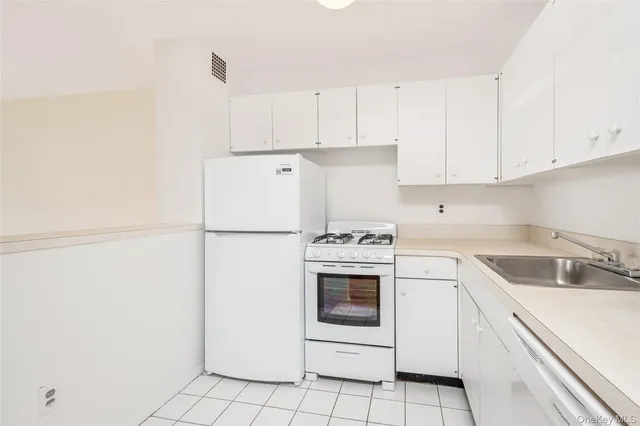 a kitchen with white cabinets and white appliances
