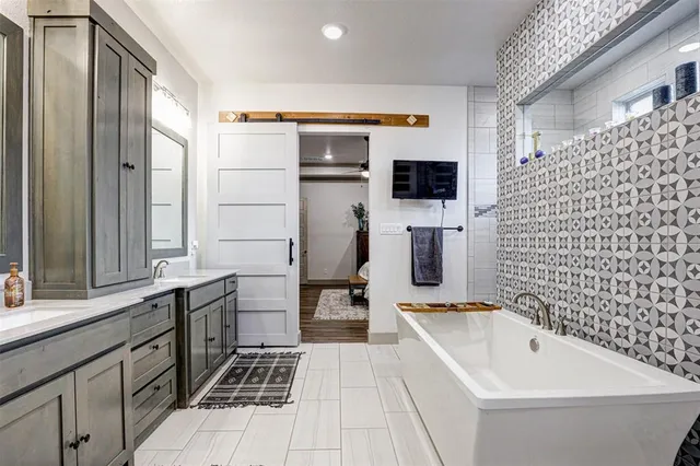 a bathroom with a bathtub sink and mirror