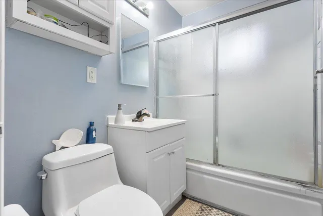a bathroom with a sink mirror vanity and toilet