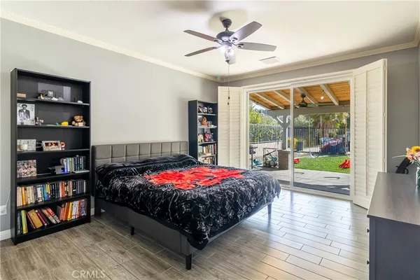 a bedroom with a bed bookshelf and a large window