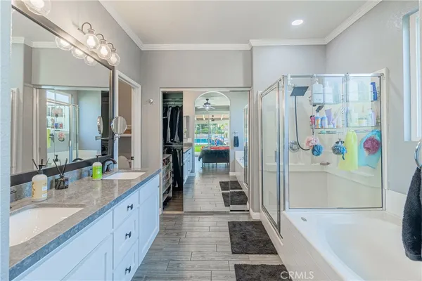 a bathroom with a granite countertop tub sink a mirror a shower and vanity