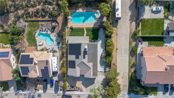 an aerial view of a residential apartment building with a yard and parking spaces