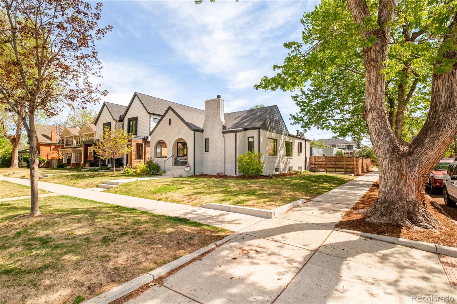 4100 Raleigh Street Denver, CO 80212 - Photo 2 of 48 a view of a white house with a large tree next to a yard