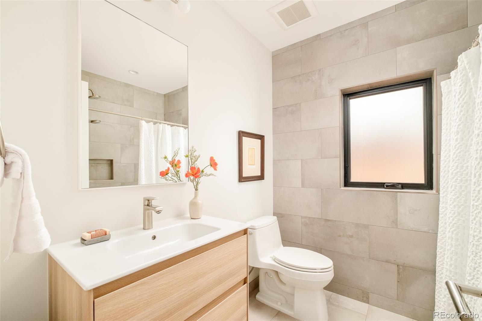 4100 Raleigh Street Denver, CO 80212 - Photo 29 of 48 a bathroom with a sink toilet and a mirror