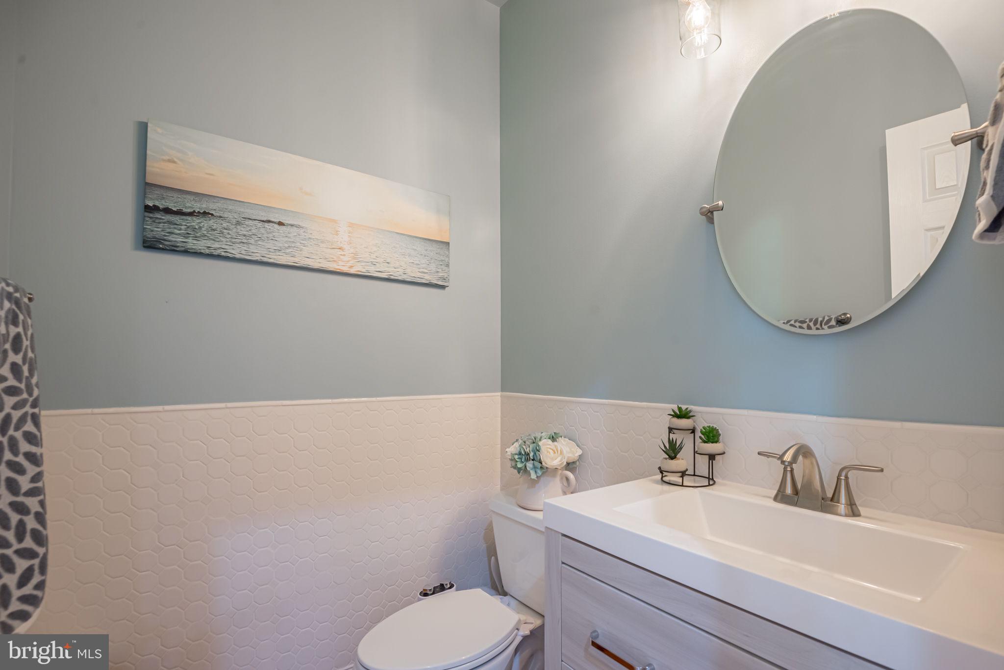 125 Cornwall Road Rehoboth Beach, DE 19971 - Photo 36 of 52 a bathroom with a toilet sink vanity and mirror