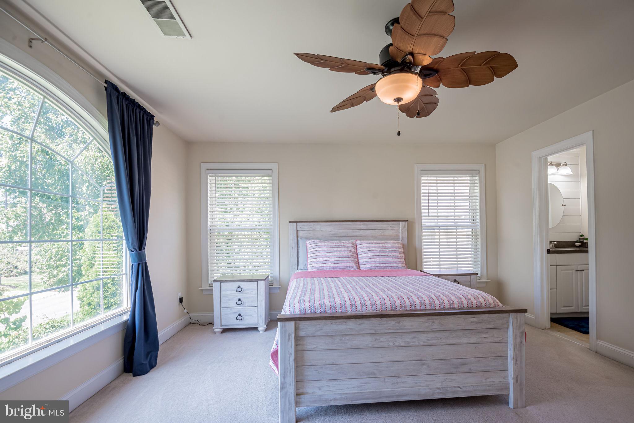 125 Cornwall Road Rehoboth Beach, DE 19971 - Photo 47 of 52 a bedroom with a large bed and a chandelier fan