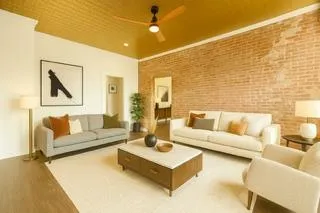 a living room with furniture and a wall painting