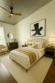 a bedroom with a bed lamp and paintings on the wall