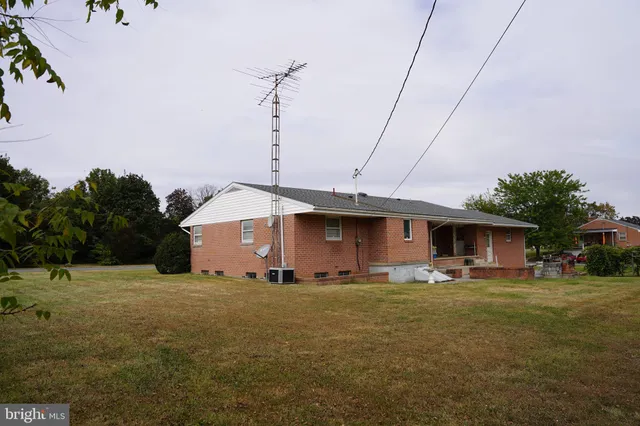 a front view of house with yard and trees in the background