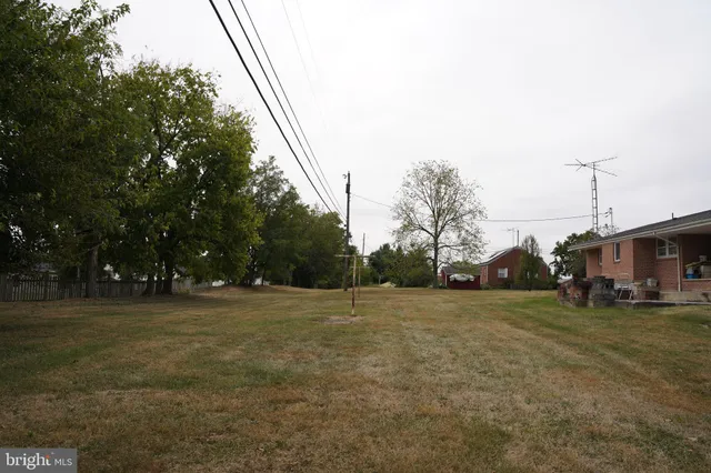 a view of a field with a white fence