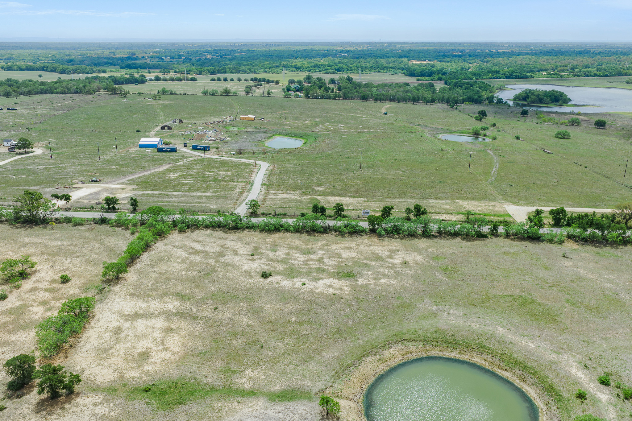 Lot 16 Mineral Springs Road Lockhart, TX 78644 - Photo 5 of 7 Expansive rural acreage featuring green pastures, multiple ponds, and a distant lake