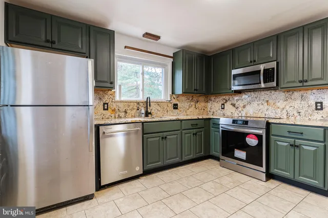 a kitchen with stainless steel appliances granite countertop a refrigerator sink and microwave