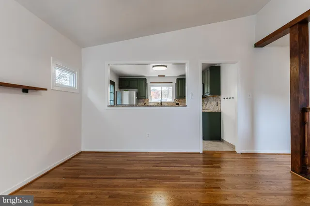 a view of a room with wooden floor and a window