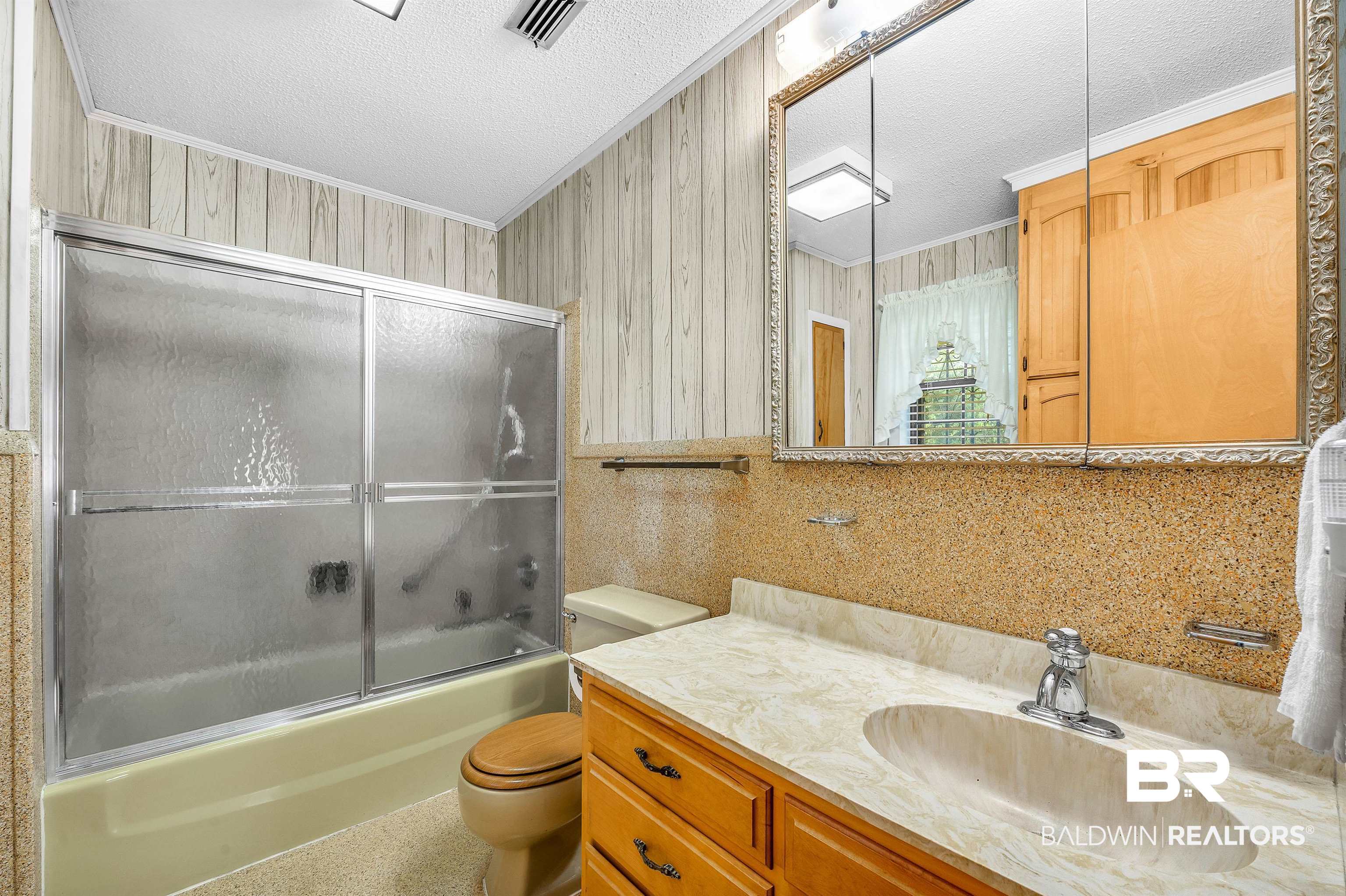 610 East Walker Avenue Foley, AL 36535 - Photo 35 of 38 Full bathroom with a textured ceiling, vanity, shower / bath combination with glass door, and ornamental molding