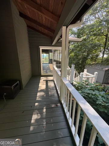 a view of an empty room with wooden floor and windows