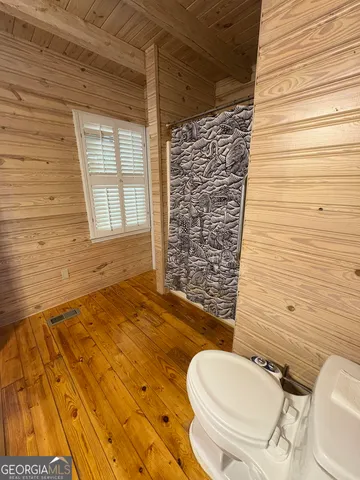 a view of swimming pool with a large window and wooden floor