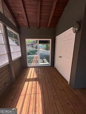 a view of a balcony with chairs and wooden floor