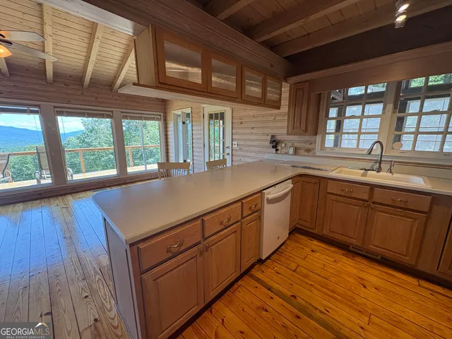 a view of a living room with wooden floor and furniture