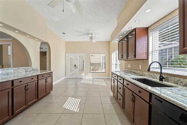 a large kitchen with granite countertop a refrigerator and a sink
