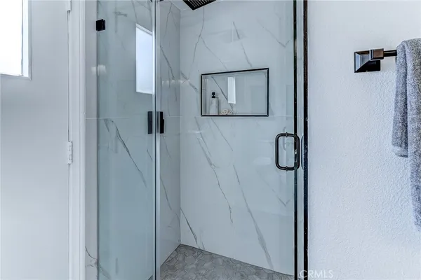 a view of hallway with stainless steel appliances refrigerator stove and cabinets