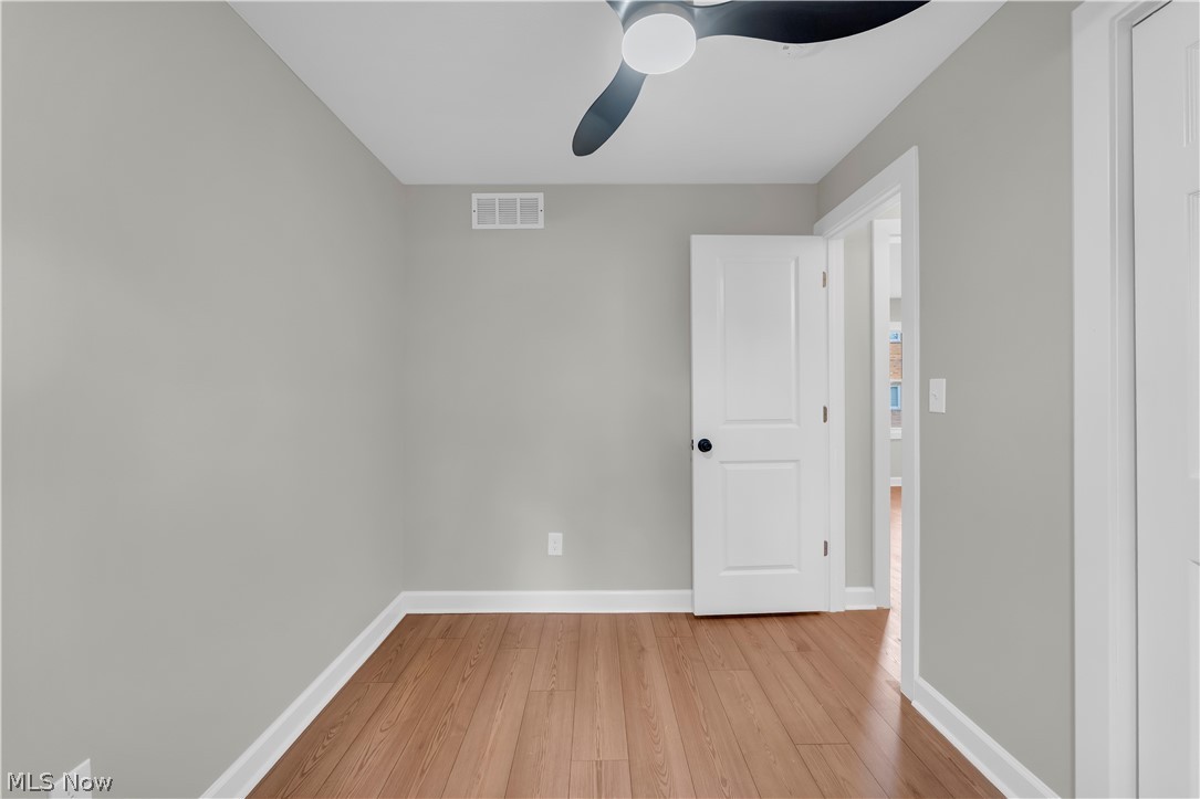 18155 Libby Road Maple Heights, OH 44137 - Photo 19 of 32 Neutral paint tones, recessed ceiling fan, wood-finish flooring, white trim, and a paneled door with black hardware