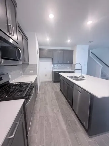 a kitchen with stainless steel appliances a sink stove and cabinets