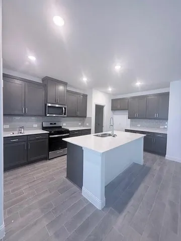 a large kitchen with a center island and stainless steel appliances